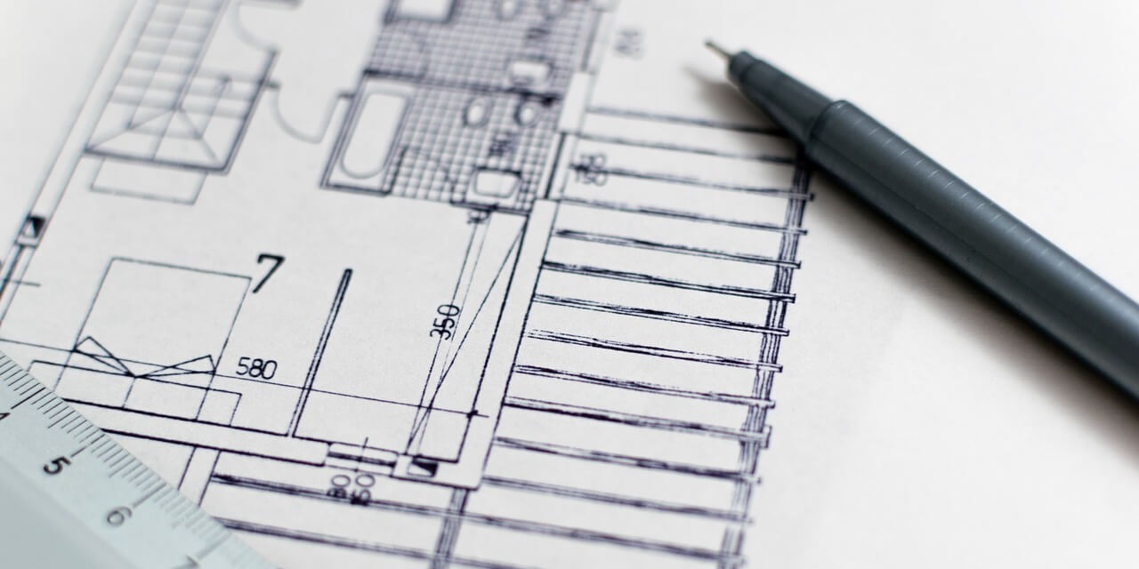 black-pen-resting-on-architects-drawings
